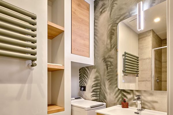Rifacimento totale del bagno, con nicchie create su misura per ottimizzare lo spazio.